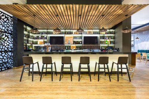 a bar in a restaurant with chairs and a counter at Holiday Inn Panama Distrito Financiero by IHG in Panama City
