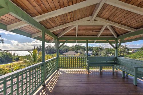 a wooden porch with a bench on a deck at Hale Ki'i Maka Manu home in Keaau
