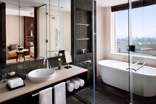 a bathroom with a tub and a sink and a shower at InterContinental Dubai Festival City by IHG in Dubai