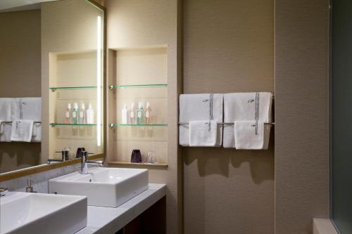 y baño con 2 lavabos, espejo y toallas. en The Lake View Toya Nonokaze Resort, en Lago Toya