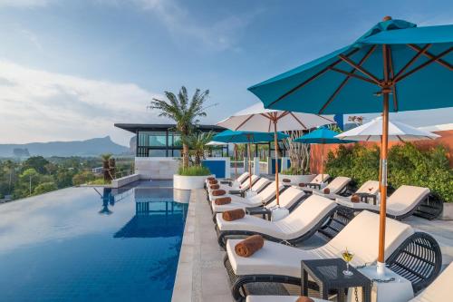 basen bez krawędzi z leżakami i parasolami w obiekcie Anda Sea Tales Resort-SHA Plus w Aonang Beach