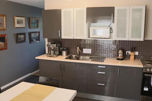 a kitchen with a sink and a microwave at Robinson Cottage in Oatlands