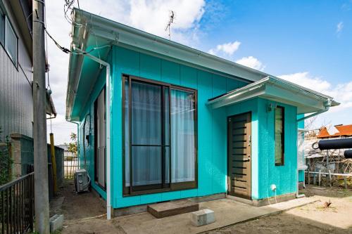 a blue house with a window at Villent Kujukuri Ocean 2 in Kujukuri