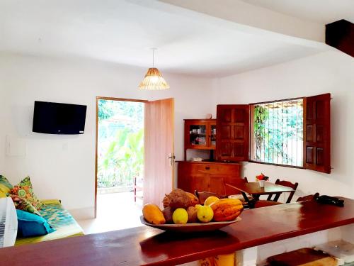una sala de estar con un bol de fruta en una mesa en Trancoso, Bahia - Casa por temporada com estacionamento, en Trancoso