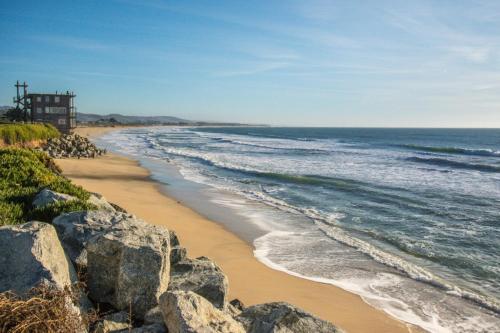 een strand met rotsen en de oceaan bij Miramar Beach Home Walk to Beach Trails Restaurants Family Activities in Half Moon Bay