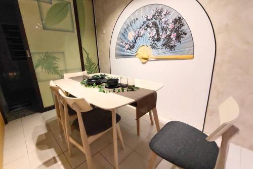 Kulai Dream Homestay 4room 16pax @near Kulai Aeon, JPO, Senai Airport, Legoland في كولايْ: غرفة طعام مع طاولة بيضاء وكراسي