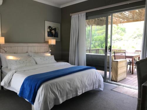 a bedroom with a bed and a sliding glass door at 78on5th in Hermanus in Hermanus