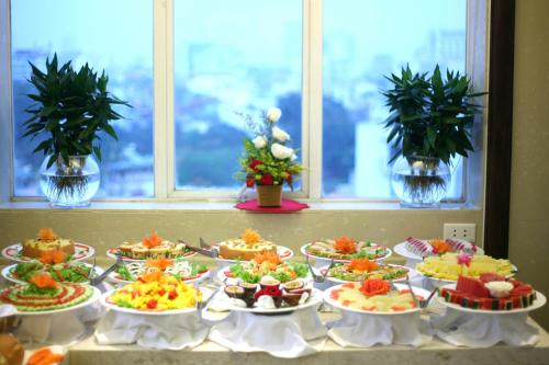 a buffet with many plates of food on a table at Hanoi Emotion Hotel in Hanoi