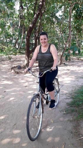 a man riding a bike down a dirt road at Green leaf Tree house in Dambulla