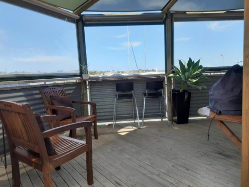 a balcony with two chairs and a potted plant at Boat Haven Studios in Goolwa