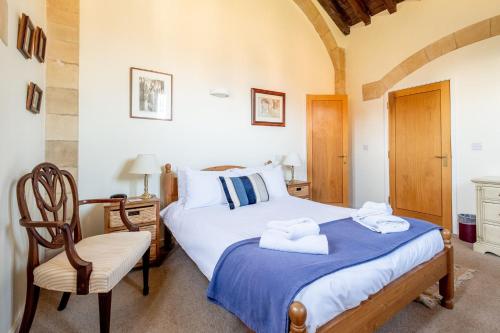 a bedroom with a bed and a chair at The Tower in Thorpeness