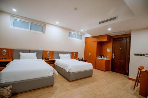 a hotel room with two beds and a bathroom at Bella Vita Hotel in Long Hai