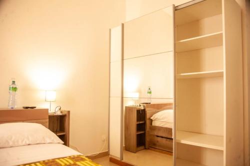 a bedroom with a mirror and a bed at Quintal di Maria in Guediawaye