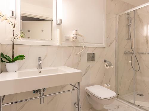 a bathroom with a sink and a toilet and a shower at VacationClub - Baltic Park Fort Apartament E.111 in Świnoujście