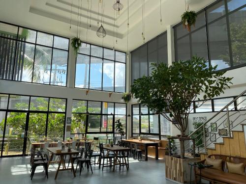 a restaurant with tables and chairs and windows at Bed in Beyt Boutique Hotel in Nonthaburi