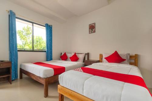 Un pat sau paturi într-o cameră la OYO 502 Roberto's Resort