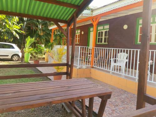 a wooden bench on a porch of a house at Bungalow PAPAYE in Pointe-Noire
