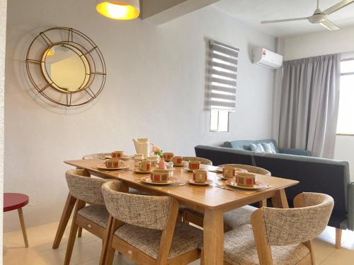 een tafel met kopjes en stoelen in de woonkamer bij Arcadia Penang by Plush in George Town