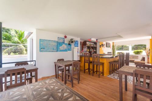 a dining room with tables and chairs and a kitchen at OYO 502 Roberto's Resort in Panglao Island