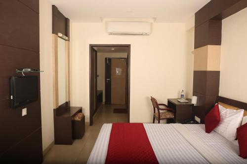 a bedroom with a bed and a desk and a television at Sri Krishna Palace in Hosūr