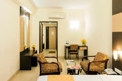 a hotel room with a bed and chairs and a table at Sri Krishna Palace in Hosūr
