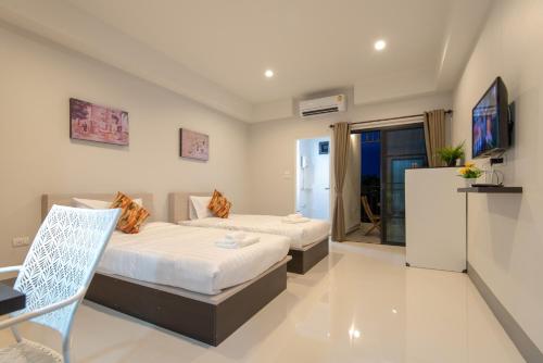 清莱J2 Residence Chiang Rai的一间有两张床和一台电视的酒店房间