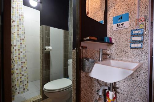 a bathroom with a sink and a toilet at Sha Feng Lu Dian in Magong