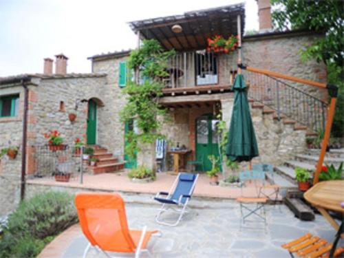an outdoor patio with chairs and an umbrella at All'Antico Silbule in Capolona