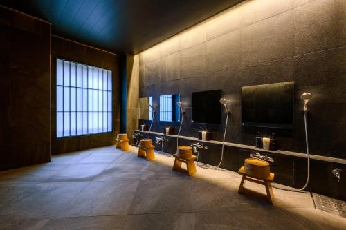 HOTEL WOOD TAKAYAMA في تاكاياما: حمام به صف من البول على الحائط