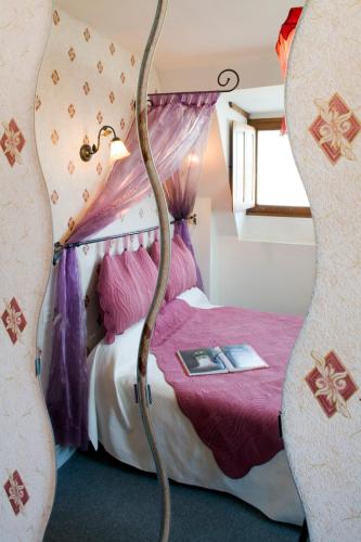 a bedroom with a bed with purple sheets at Logis Hôtel Restaurant Le Puits Doré in Richelieu