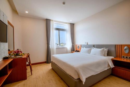 a hotel room with a large bed and a window at Bella Vita Hotel in Long Hai