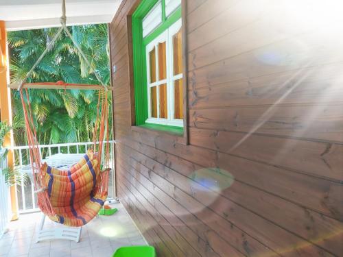 a porch with a hammock and a window at Bungalow PAPAYE in Pointe-Noire