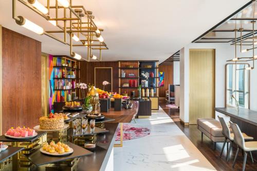 a lobby of a hotel with tables and chairs at Swissôtel Jakarta PIK Avenue in Jakarta