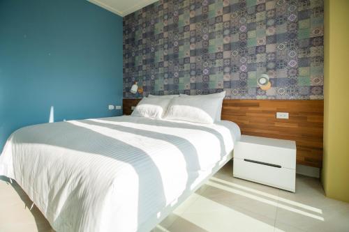 a bedroom with a large bed with a blue wall at Chance Villa 262 in Jiaoxi