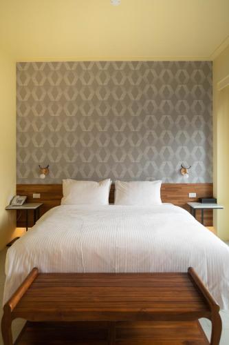 a bedroom with a large white bed with a wall at Chance Villa 262 in Jiaoxi