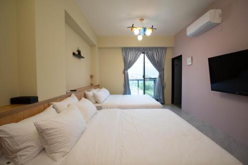 a hotel room with two beds and a flat screen tv at Chance Villa 262 in Jiaoxi