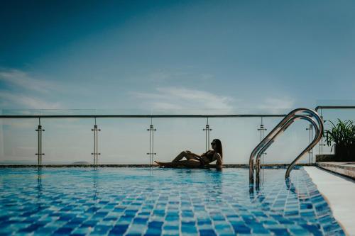 a woman in a bikini sitting in a swimming pool at Navada Beach Hotel in Nha Trang