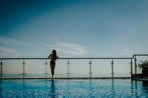 a woman standing on the edge of a swimming pool at Navada Beach Hotel in Nha Trang