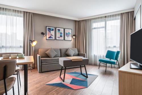 un salon avec un canapé et une table dans l'établissement Aparthotel Adagio Paris Nation, à Paris