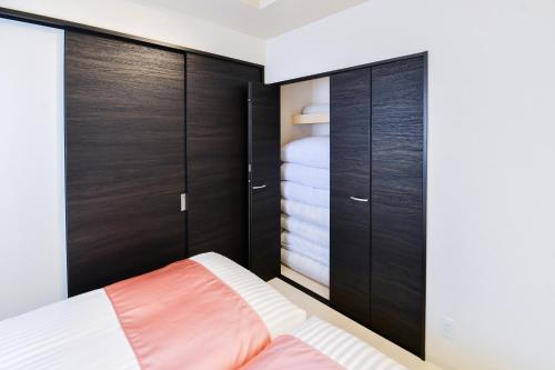a bedroom with wooden cabinets and a bed at momo premium 202 in Sapporo