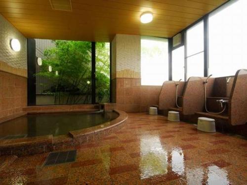 a bathroom with chairs and a tub in a building at Genpeiso in Shimonoseki