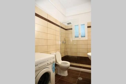 a bathroom with a washing machine and a toilet at Andreas Naxos Center - House in Naxos Chora