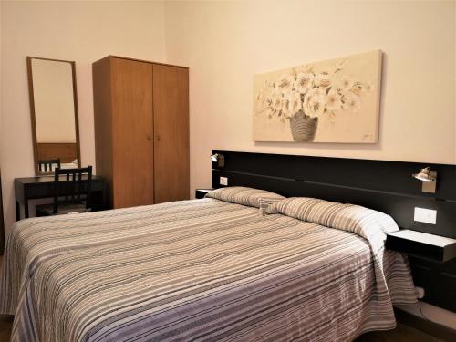 a bedroom with a bed with a striped blanket at Hotel Rossi in Venice