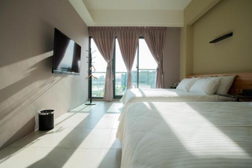 a hotel room with two beds and a window at Chance Villa 262 in Jiaoxi