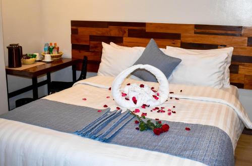 a bed with a basket and roses on it at Hotel Lourdes in Laoag