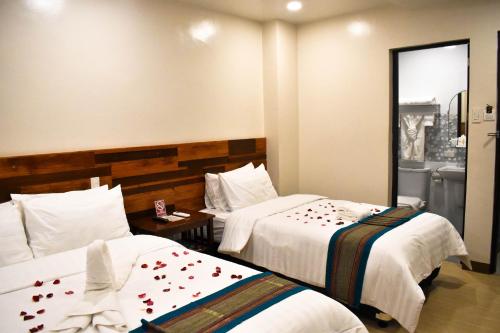 a hotel room with two beds with flowers on them at Hotel Lourdes in Laoag