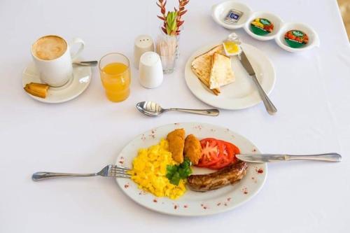 a white table with a plate of food with eggs and toast at Appledew Guesthouse in Standerton