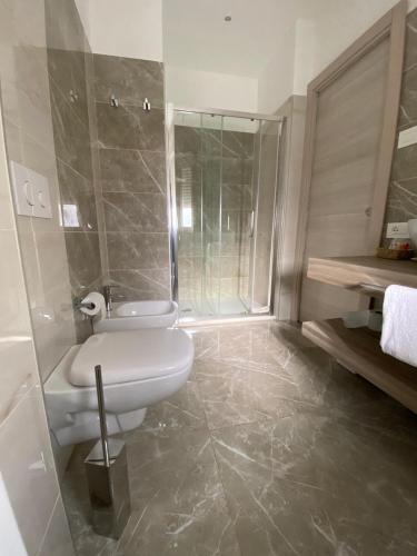 a bathroom with a toilet and a shower at Hotel Victoria in Cuneo