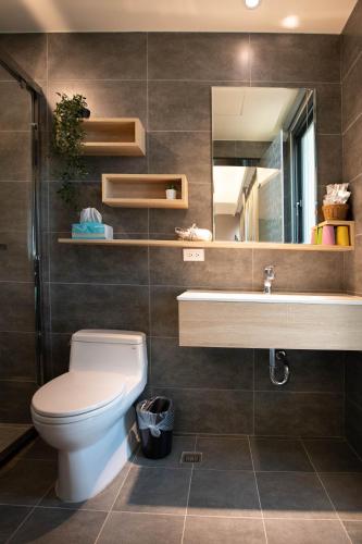 a bathroom with a toilet and a sink and a mirror at Chance Villa 262 in Jiaoxi