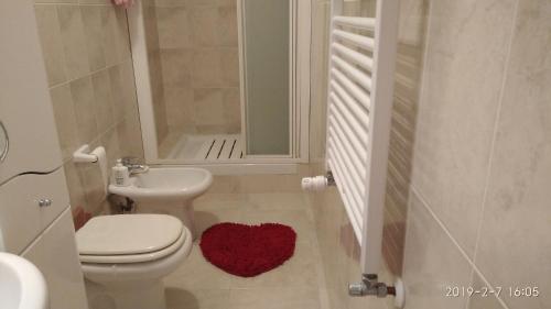 ein Badezimmer mit einem weißen WC und einem Waschbecken in der Unterkunft Alle rose barcolane in Triest